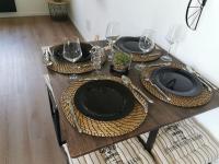 a wooden table with black plates and glasses on it at LE MEDITERRANEEN *T2 (40m²) *WIFI*PARKING PRIVE* in Lourdes