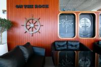 a red wall with two chairs and an anchor on the boat at Naiharn On The Rock Resort Phuket in Nai Harn Beach