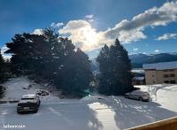 two cars parked in a parking lot in the snow at Appartement idéalement situé Font romeu in Font-Romeu-Odeillo-Via