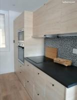 a kitchen with wooden cabinets and a black counter top at Appartement idéalement situé Font romeu in Font-Romeu-Odeillo-Via