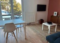 a living room with a white table and a tv at Appartement idéalement situé Font romeu in Font-Romeu-Odeillo-Via
