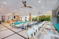 Un restaurante con mesas y sillas y un bar. en RV Hotel Gianyar, en Gianyar