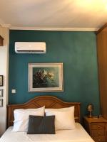 a bedroom with a green wall with a bed and a air compressor at Villa Casa Chrissy in Plagiárion