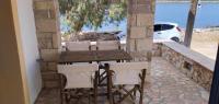 a wooden table and chairs with a view of the ocean at Diakofti house by the sea - Kythoikies hoilday houses in Kythira