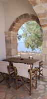a wooden table and chairs in a room with a window at Diakofti house by the sea - Kythoikies hoilday houses in Kythira