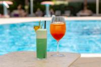 Een drankje en een kaars op een tafeltje naast een zwembad. bij Martinhal Quinta Family Resort in Quinta do Lago