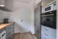 a kitchen with a stainless steel refrigerator and a microwave at Detente au calme et pres de la plage in Saint-Gildas-de-Rhuys