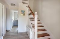 a staircase in a home with white walls and wooden floors at Detente au calme et pres de la plage in Saint-Gildas-de-Rhuys