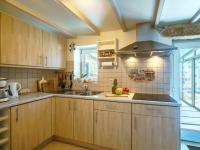 una cocina con armarios de madera y fregadero en Holiday Home L&#39;Iroise by Interhome, en Plogoff