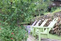 a row of white chairs sitting in a garden at Bear Meets Moose Homestay B&amp;B in Puli