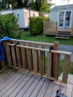 a wooden fence on a deck in a yard at Mobilhome 6 pers avec Clim in Saint-Georges-de-Didonne