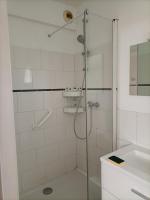 a shower with a glass door next to a sink at La Jolie Dourbie de Nant in Nant