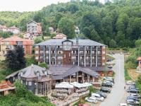 a large building with cars parked in a parking lot at Vlasinsko jezero VILA BEST in Surdulica