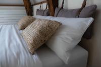 a bed with white pillows on top of it at Suite Toussaint - Calme &amp; Authentique in Angers