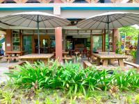 duas mesas de piquenique com guarda-chuvas em frente a um edifício em Heart of Mother Earth (HOME) Resort em Aringay