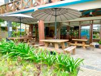 duas mesas de piquenique com guarda-chuvas em frente a um edifício em Heart of Mother Earth (HOME) Resort em Aringay