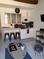 a living room with a table and a kitchen at La Maison du Bonheur - Logement entier de 39 m2 in Bourg-en-Bresse