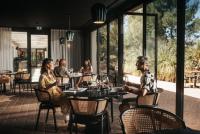 斯塔里格勒Maslina Resort的一群人坐在餐厅的桌子旁