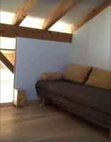 a bedroom with a couch in a room with wooden ceilings at Les Faveyrolles à Labeaume in Labeaume