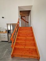 a wooden staircase in a kitchen with a refrigerator at A l&#39;Orée du Lac, 500m lac de Chamboux in Saint-Martin-de-la-Mer