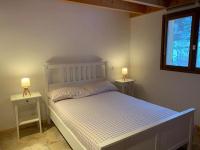 a bedroom with a white bed with two night stands at APPARTEMENT DANS CHALET 6 PERSONNES in Vallouise