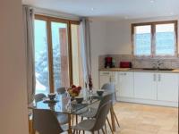 a dining room with a glass table and chairs in a kitchen at APPARTEMENT DANS CHALET 6 PERSONNES in Vallouise