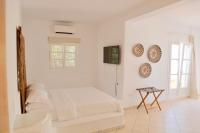 a white bedroom with a bed and a table at Ubud Mykonos in Agios Ioannis Mykonos