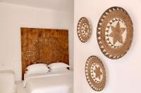 a bedroom with plates on the wall and a bed at Ubud Mykonos in Agios Ioannis Mykonos