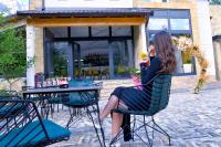 una mujer sentada en una silla en una mesa en Breezy Hotel, en Valbonë