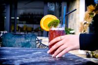 una persona sosteniendo una bebida con una rodaja de lima en Breezy Hotel, en Valbonë