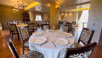 a dining room with a white table and chairs at Hotel Tolea in Târgovişte