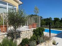 a garden with a fence and a swimming pool at Villa Yucca Istra in Labin