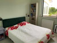 a bedroom with a bed with a white blanket with red flowers at Villa Yucca Istra in Labin