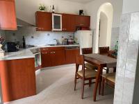 a kitchen with wooden cabinets and a table with chairs at Villa Yucca Istra in Labin