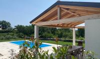 a wooden pergola over a patio with a pool at Villa Yucca Istra in Labin