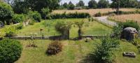 an outdoor garden with fruit trees and a fence at Respire O&#39;Dorat chambres privées dans havre de paix in Le Dorat