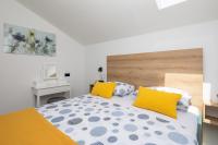 a bedroom with a bed with yellow and white pillows at Modern suite Beleca near Split in Solin