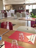 a restaurant with wooden tables and chairs and tables and tablesktop at Campanile Saint-Etienne Est- Saint-Chamond in Saint-Chamond