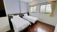 two beds in a room with two windows at Sun B&amp;B in Taitung City