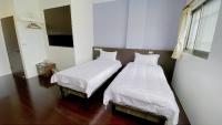 two beds sitting next to each other in a room at Sun B&amp;B in Taitung City