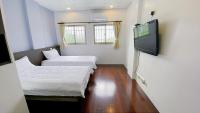 a room with two beds and a flat screen tv at Sun B&amp;B in Taitung City