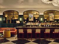 een vrouw die aan een bar in een restaurant zit bij InterContinental Edinburgh The George by IHG in Edinburgh