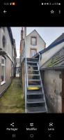 a picture of a staircase with a clock on a building at Très bel appartement cosy en hyper centre in Romorantin