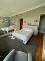 a bedroom with two beds and a couch at Spacieux et élégant appartement Porte des ternes in Paris