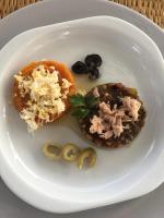 un piatto bianco con un panino con carne e olive di Tamalou Djerba a Midoun