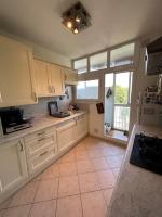 a kitchen with white cabinets and a large window at Logement spacieux idéal famille in Marseille