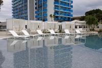 una piscina con tumbonas blancas y un edificio en BG Tonga Tower, en Can Picafort