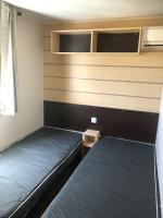 a small room with two beds and a window at Mobil home in Damiatte