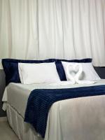 una cama con sábanas azules y blancas y dos almohadas blancas en Haki Hotel, en Patos