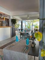 un comedor con mesa y sillas y un restaurante en Hôtel Le Grand Bleu, en Saint-Gilles-les-Bains